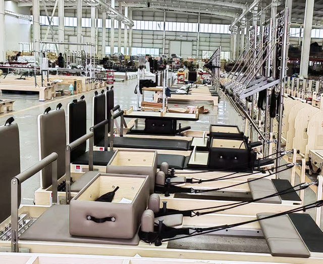 Factory workers assembling Pilates reformers